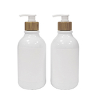 Botella blanca de la loción del cuarto de baño con la bomba de bambú para el lavado del champú y del cuerpo